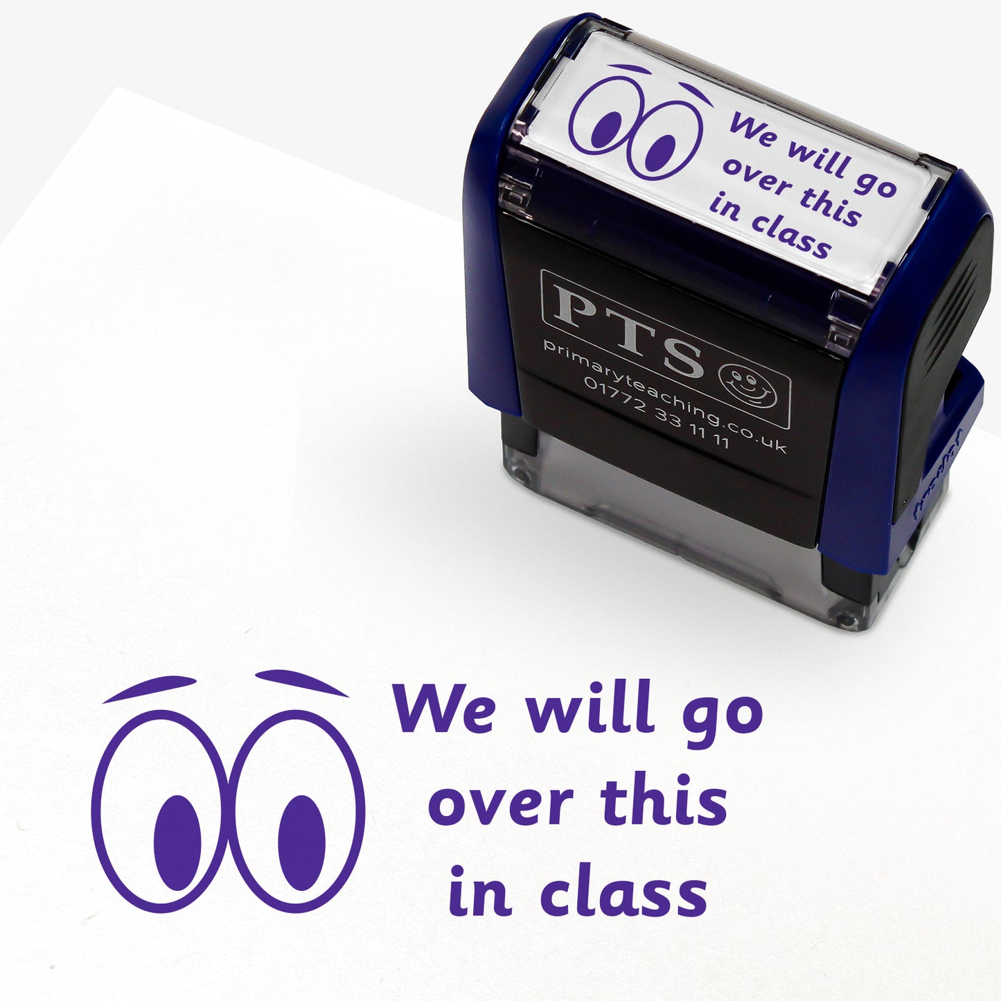 A rectangular pre-inked teacher stamper measuring 38mm x 15mm, featuring a purple ink impression of two cartoon eyes beside the phrase "We will go over this in class" in a playful, rounded font. The stamper has a dark blue casing with the PTS logo and contact details on the front, designed for marking pupils' work to indicate topics to be revisited during class discussions.