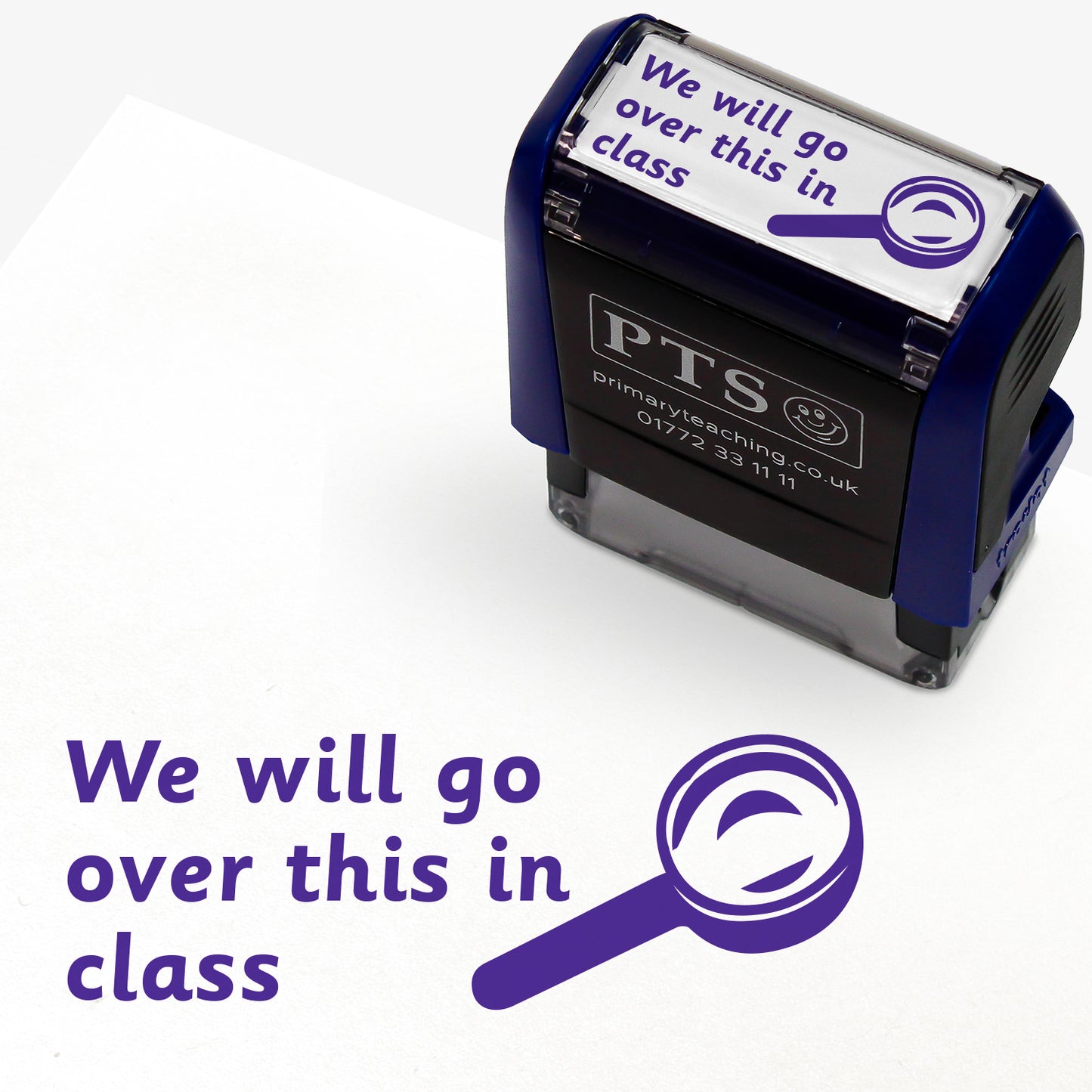 Rectangular self-inking stamper 38mm x 15mm with purple ink, displaying the text 'We will go over this in class' alongside the outline of a magnifying glass.