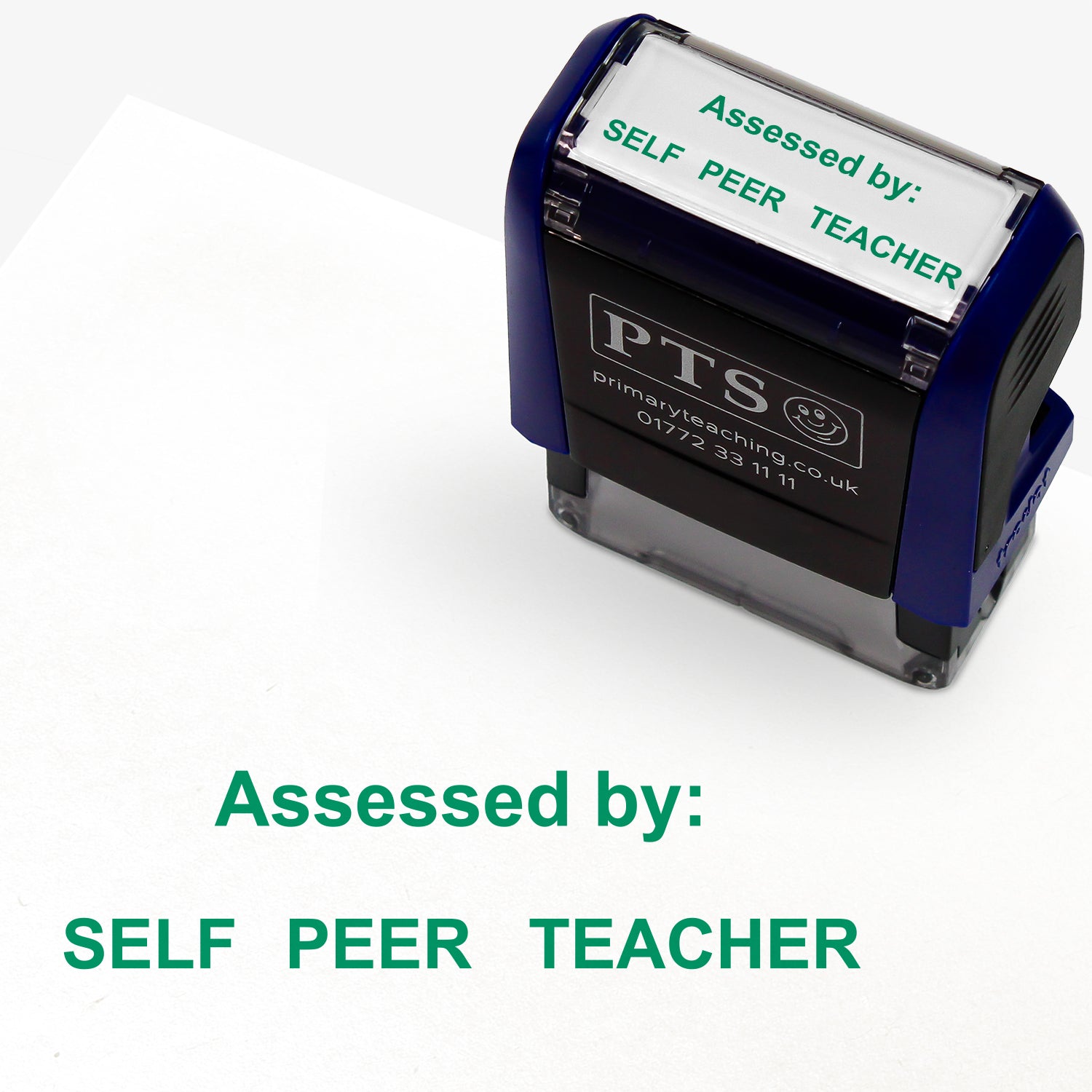A rectangular self-inking stamper with a dark blue casing, displaying the green text 'Assessed by:' and 'SELF   PEER   TEACHER'; the stamped impression measures 38mm by 15mm