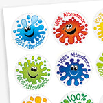 A sheet of 32mm round stickers featuring colourful splash designs in red, blue, green, and orange, each with a smiling face and the text '100% Attendance'. Ideal for rewarding pupils' perfect attendance.