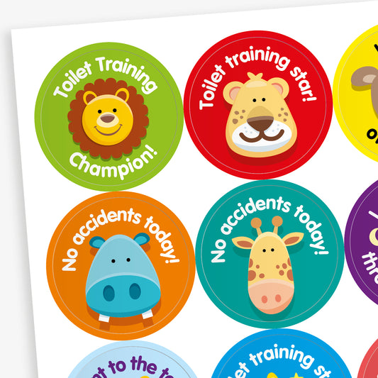 Sheet of round toilet training reward stickers featuring cartoon animals and encouraging messages. Designs include a lion with 'Toilet Training Champion!', a lion with 'Toilet training star!', a hippo and giraffe with 'No accidents today!', all in vibrant colours with playful fonts.