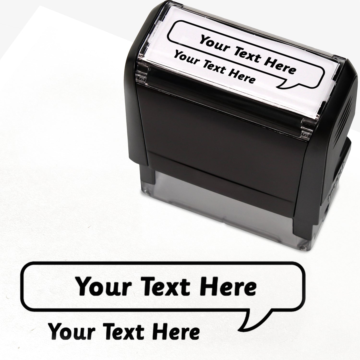 Rectangular self-inking stamper measuring 59mm by 21mm, featuring the phrase 'Your Text Here' leading onto a speech bubble going above it also saying 'Your Text Here'. In black ink.