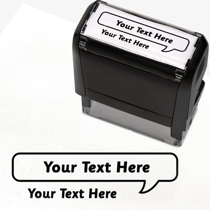Rectangular self-inking stamper measuring 59mm by 21mm, featuring the phrase 'Your Text Here' leading onto a speech bubble going above it also saying 'Your Text Here'. In black ink.
