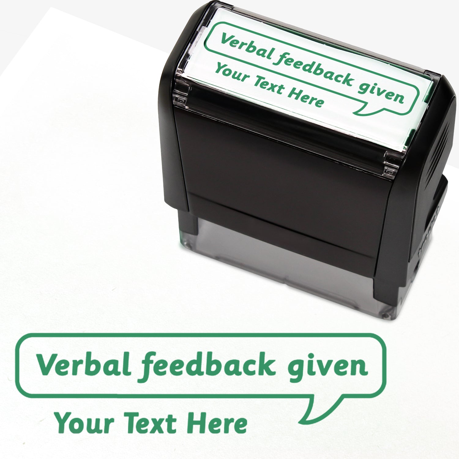 Rectangular self-inking stamper measuring 59mm by 21mm, featuring the phrase 'Your Text Here' leading onto a speech bubble going above it also saying 'Verbal Feedback Given'. In green ink.