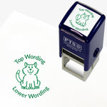 A 25mm round pre-inked teacher stamper with green ink, featuring a fluffy cat sat up, curving above the image is space for personalisation 'Top Wording' and curving below the image is space for personalisation 'Lower Wording' in a clear, bold font.