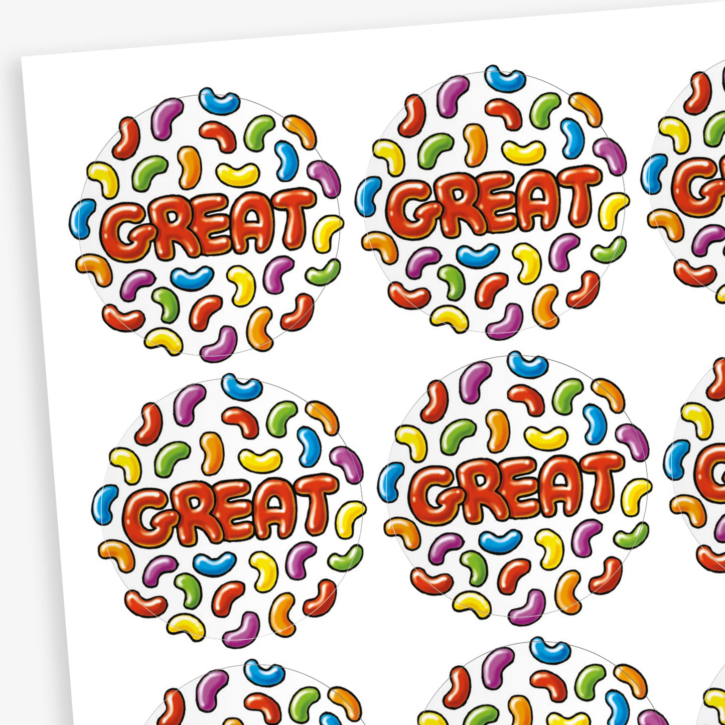 A sheet of jellybean scented round reward stickers, each featuring the word 'GREAT' in bold red-orange letters at the centre. The background is filled with a colourful pattern of jelly bean shapes in various colours including blue, yellow, green, purple, red, and orange. The playful design is vibrant and engaging,