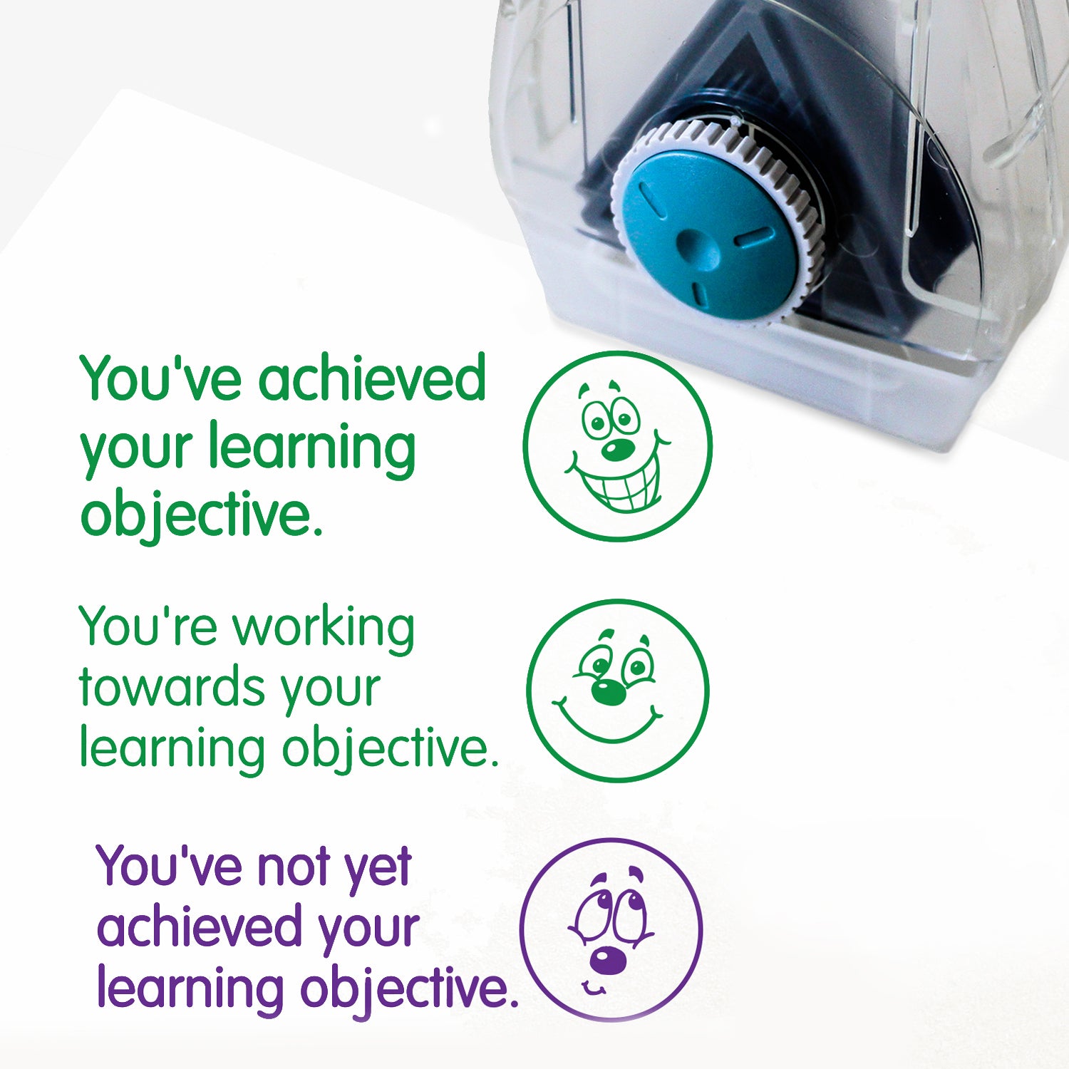 Complete Twist N Stamp.  Brick 1 Green ink -very happy face with phrase 'You've achieved your learning objective'.  Brick 2 green ink with smiling face and phrase 'You're working towards your learning objective'  Brick 3 in purple ink with unsure face and phrase 'You've not yet achieved your learning objective'.