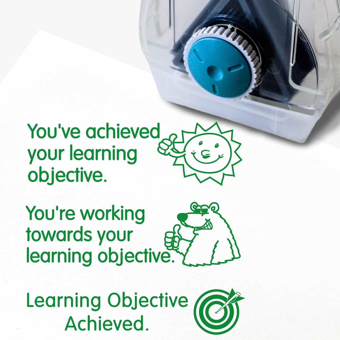 Complete Twist N Stamp.  Brick 1 Green ink -very happy face with phrase 'You've achieved your learning objective'.  Brick 2 green ink with smiling polar bear and phrase 'You're working towards your learning objective'  Brick 3 in green ink with unsure face and phrase 'You've not yet achieved your learning objective'.
